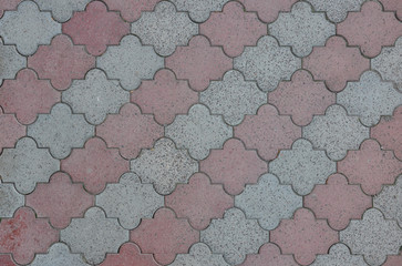Red and gray road tiles of city street pavement. Cobblestone pathway paved with decorative concrete bricks