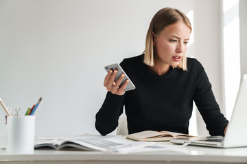 Business woman in office work with documents and phone.