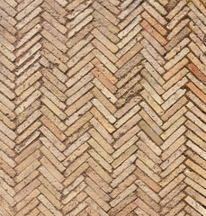 Pattern with modern rectangular herringbone yellow tiles. Diagonal texture. Abstract backdrop of old  brick ceramic cobblestone pavement close-up.