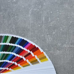 Color palette guide, fan, catalogue on grey background. Ral color fan on conсrete floor © MishAnia
