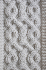 Knitted fabric texture with braids. Knitted woolen background. Beautiful white wool hand knit patterns 