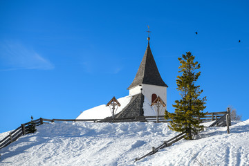 Fototapeta na wymiar die 2045 m hoch gelegene schöne Kapelle von Heilig Kreuz in den Dolomiten befindet sich unter der Wand des Heiligkreuzkofels in unvergleichlich schöner Lage. Sie ist Ausflugsziel und Pilgerstätte 
