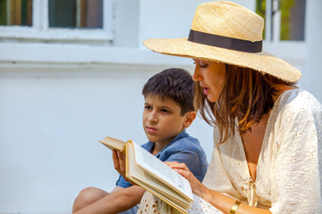 Woman and boy are reading a book