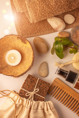 Spa and wellness concept, natural coffee scrub soap in cotton eco bag, coconut oil cosmetic, peeling sand stone,towel,wooden haircomb.Beige dayspa set.Pastel bathroom accessories and products top view