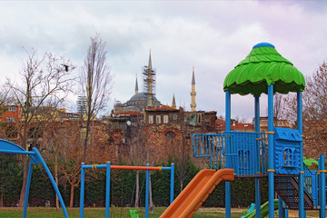 Empty playground is waiting little kids. Famous Sultan Ahmed Mosque in the background. Cloudy day in Istanbul, Turkey