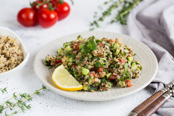 Quinoa salad with fresh tomatoes, cucumbers and salad leaves. Superfood and healthy eating concept.