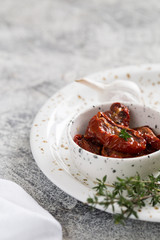 sun-dried tomatoes in a plate on a light concrete background