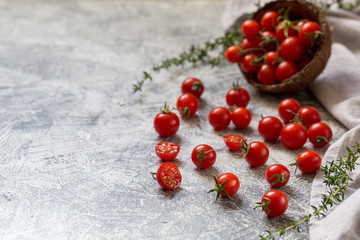 Tiny cherry tomatoes (ciliegini, pachino, cocktail). group of cherry tomatoes on a gray concrete background. ripe and juicy cherry tomatoes