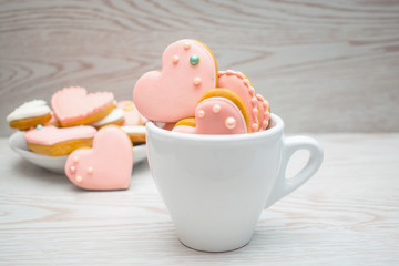 Gingerbread heart shaped cookies in a cup and on a plate. Macro view.