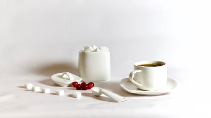 Obraz na płótnie Canvas White coffee mug with coffee and lumps of sugar