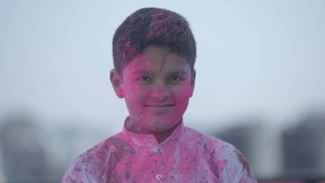 Boy enjoying festival of colors- Holi, an Indian Festival. Holi is celebrated all over India. Boy full covered with colors., enjoying the festival.Kids playing Holi Festival.Colors splash