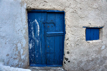 Old vintage blue wooden door with rustic stone wall