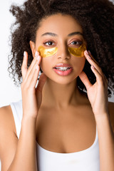 curly african american girl with golden eye patches, isolated on grey