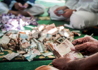 A group of men counting charity money at a mosque.