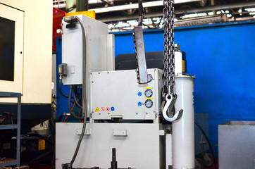 Crane hook of the overhead crane in the workshop of an industrial plant.  Push remote control switch for lifting crane in the factory