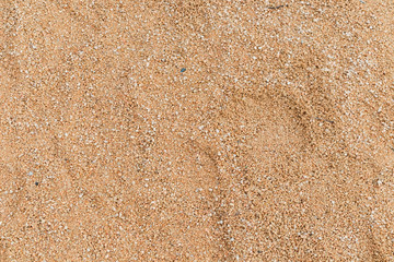 Fototapeta na wymiar arena de playa de un parque infantil. marron amarillo. piedrecitas. textura.