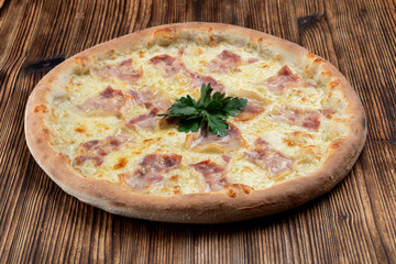 Hot italian pizza with melted cheese and bacon strips on wooden background