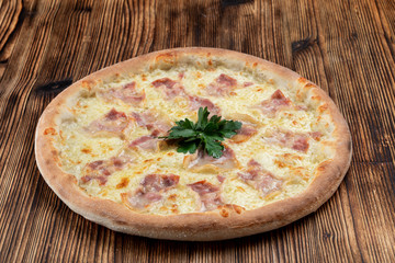 Hot italian pizza with melted cheese and bacon strips on wooden background