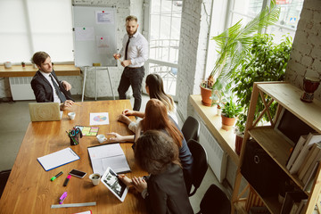 Top view. Group of young business professionals having a meeting. Diverse group of coworkers...
