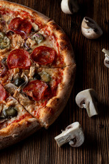 Close up of hot and spicy pizza with jalapeno, pepperoni and red onion on dark wooden background