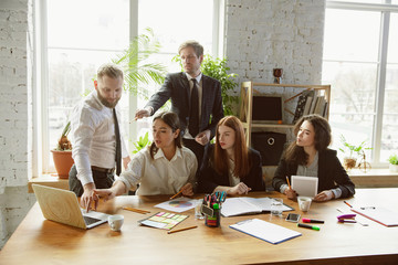 Already done. Group of young business professionals having a meeting. Diverse group of coworkers discussing new decisions, plans, results, strategy. Creativity, workplace, business, finance, teamwork.