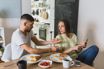 young couple arguing in kitchen during breakfast. relationship problems