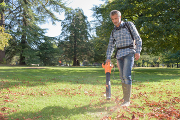 a man is hoovering leaves