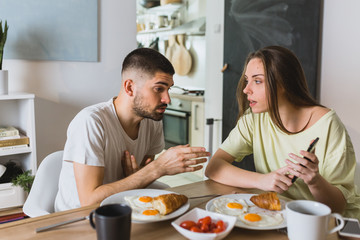 young couple arguing in kitchen during breakfast. relationship problems