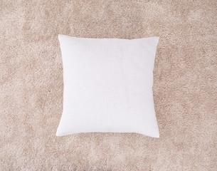 White cushion on the brown mat. One pillow with burlap case. Top view.