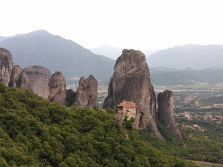 Monastery on a mountain peak in Meteora Greece surrounded by limestone peaks and background of grey mountains - Powered by Adobe