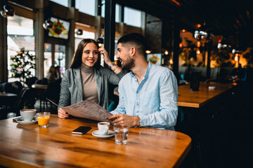 couple friends ordering food in restaurant