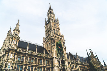 The New Town Hall, Neues Rathaus on Marienplatz main square, city government building with a tower clock. Gothic style. Photographed from below. Wide shot.