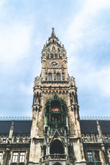 The New Town Hall, Neues Rathaus on Marienplatz main square, city government building with a tower clock. Gothic style. Photographed from below. Wide shot.