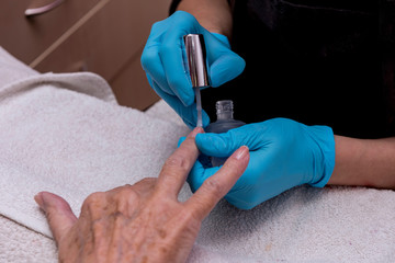 Close-up of the hands of an elderly woman, who are doing manicure