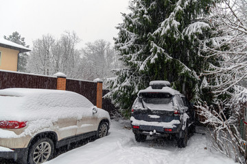 Cars are parked on the street after snow storm. Cars are covered in snow after heavy snowfall