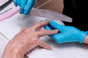 Close-up of the hands of an elderly woman, who are doing manicure
