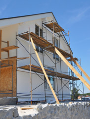 House renovation facade with wall insulation, plastering, paiting walls. House remodel construction...