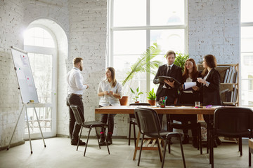 Second family. Group of young business professionals having a meeting. Diverse group of coworkers discuss new decisions, plans, results, strategy. Creativity, workplace, business, finance, teamwork.