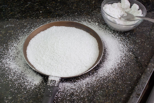 Making tapioca, a brazilian snack, with a bowl of tapioca starch or biju. 