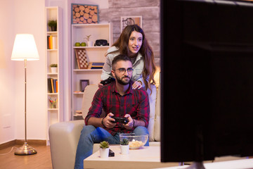 Photo of young couple playing video games on television