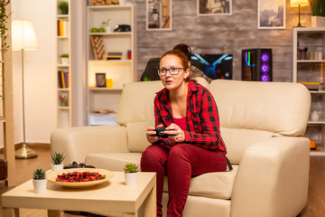 Woman gamer playing video games on the console in the living room