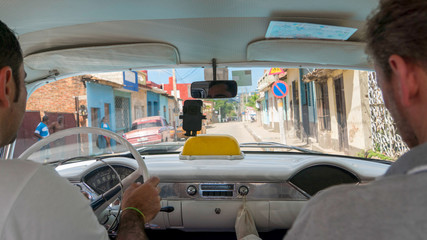 inside a cuban classic car taxi on a trip through in trinidad, taken from the back seat, cuba