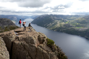 tourists stand on the edge of rock and admire the landscape