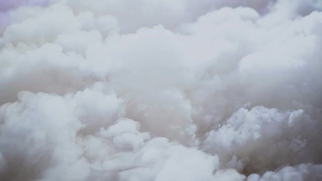 Thick stage smoke from fog machine illuminated by party lights, slow motion