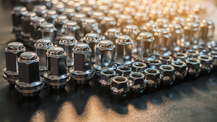 metal wheel nuts laid out on the surface, blurred image, car maintenance, replacing wheels