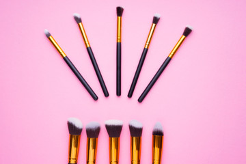 Creative arrangement of cosmetics products on pink background.