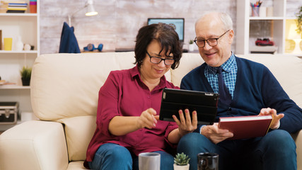 Senior couple waving at tablet during a video call