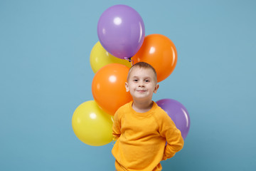 Fototapeta na wymiar Little cute kid boy 4-5 years old have fun celebrating birthday holiday party with colorful air balloons isolated on pastel blue wall background. People sincere emotions, childhood lifestyle concept.