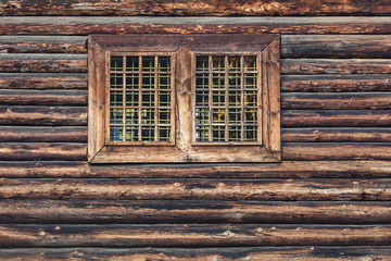 Window with bars in an old log house.
