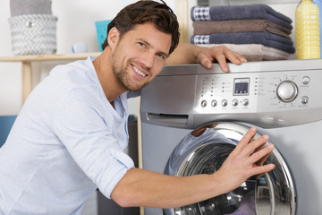 Obraz premium repairman repairing washing machine in the kitchen